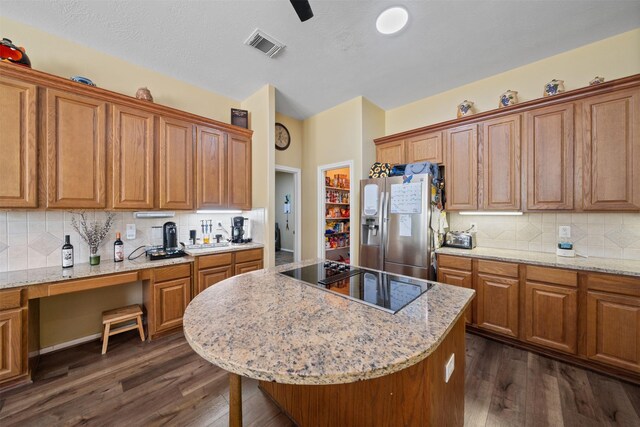 210 Southwood Cir, Baytown, TX 77520 - kitchen with stainless steel fridge, black electric cooktop, dark wood-style floors, and brown cabinets