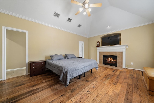 210 Southwood Cir, Baytown, TX 77520 - bedroom featuring vaulted ceiling, wood-type flooring, a tile fireplace, crown molding, and ceiling fan