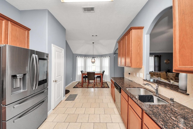 118 Long Canyon Ln, Richmond, TX 77469 - kitchen with appliances with stainless steel finishes, arched walkways, light tile patterned floors, dark stone countertops, and vaulted ceiling