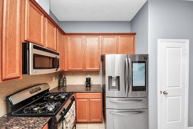 118 Long Canyon Ln, Richmond, TX 77469 - kitchen with appliances with stainless steel finishes, tasteful backsplash, dark stone countertops, and light tile patterned floors