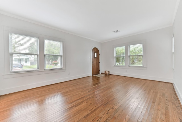 4701 Avenue N 1/2 Ave N 1/2, Galveston, TX 77551 - spare room featuring crown molding, healthy amount of natural light, arched walkways, and wood finished floors