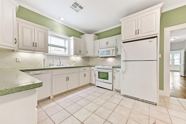 4701 Avenue N 1/2 Ave N 1/2, Galveston, TX 77551 - kitchen with white appliances, plenty of natural light, ornamental molding, decorative backsplash, and light tile patterned floors