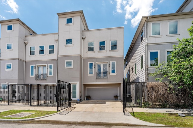 1822 Mcilhenny St Unit A, Houston, TX 77004 - view of front of property with stucco siding, an attached garage, concrete driveway, and a gate
