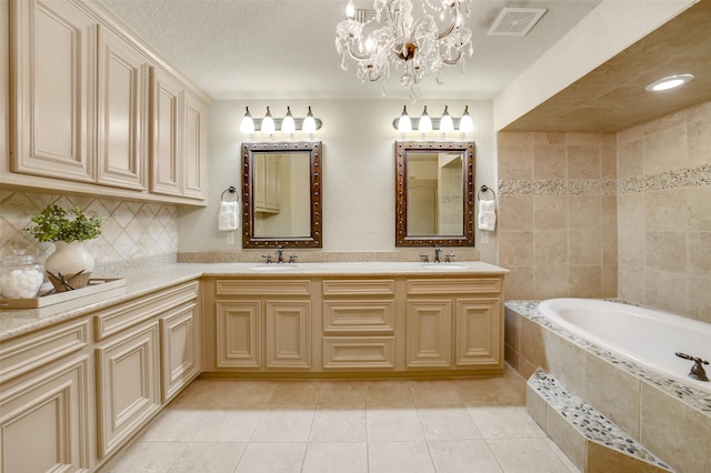 18120 County Road 127, Pearland, TX 77581 - bathroom with a bath, double vanity, tile patterned flooring, decorative backsplash, and a chandelier