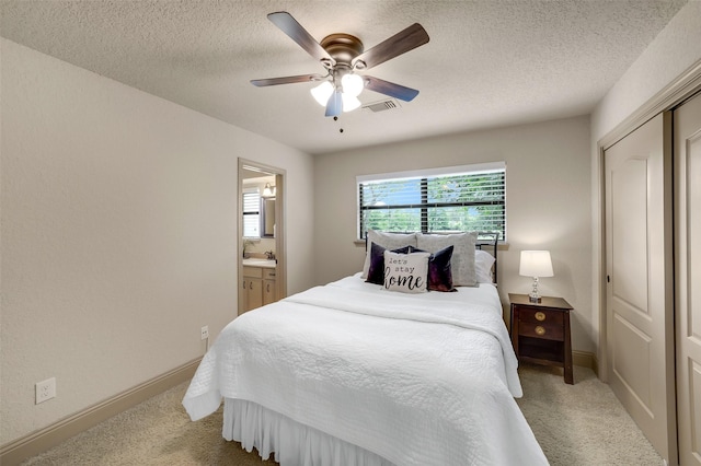 18120 County Road 127, Pearland, TX 77581 - bedroom with light carpet, a closet, a textured ceiling, ceiling fan, and ensuite bath