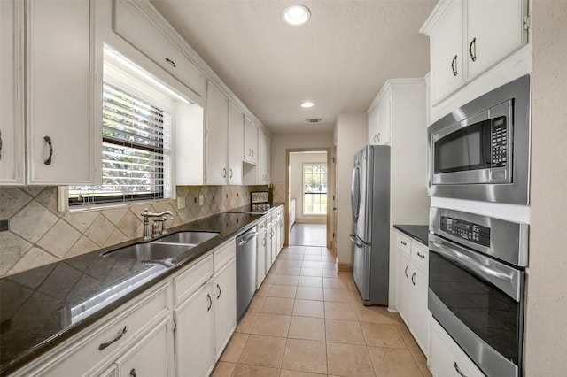 18120 County Road 127, Pearland, TX 77581 - kitchen featuring appliances with stainless steel finishes, plenty of natural light, white cabinetry, tasteful backsplash, and recessed lighting