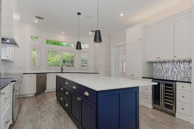 25 Red Sable Pt, The Woodlands, TX 77380 - kitchen featuring beverage cooler, appliances with stainless steel finishes, white cabinets, custom exhaust hood, and backsplash