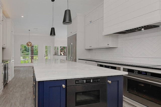 25 Red Sable Pt, The Woodlands, TX 77380 - kitchen featuring custom exhaust hood, blue cabinetry, a kitchen island, white cabinetry, and appliances with stainless steel finishes