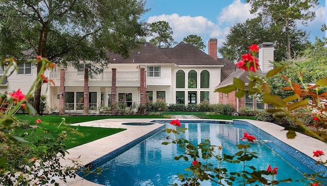 25 Red Sable Pt, The Woodlands, TX 77380 - back of house featuring a balcony, an outdoor pool, an in-ground hot tub, a lawn, and a patio