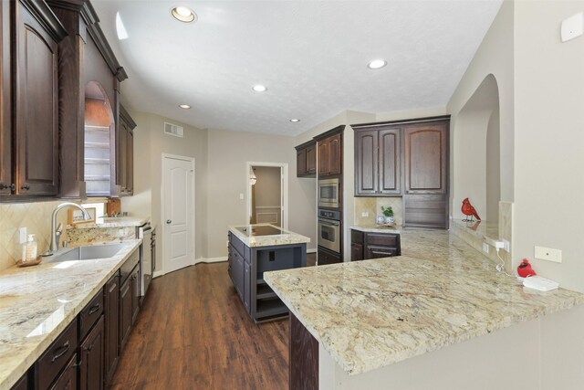 17310 Calico Peak Way, Cypress, TX 77433 - kitchen with appliances with stainless steel finishes, arched walkways, dark wood-type flooring, tasteful backsplash, and recessed lighting