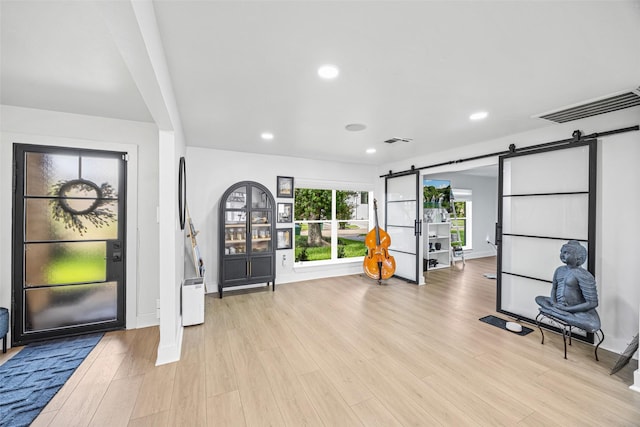 5122 Glenmeadow Dr, Houston, TX 77096 - workout area with a barn door, light wood-style floors, and recessed lighting