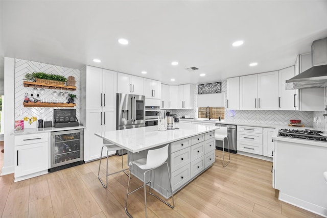 5122 Glenmeadow Dr, Houston, TX 77096 - kitchen with beverage cooler, stainless steel appliances, decorative backsplash, a kitchen island, and white cabinetry