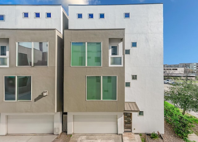 427 Tuam St Unit B, Houston, TX 77006 - multi unit property with stucco siding, a garage, driveway, a standing seam roof, and a metal roof