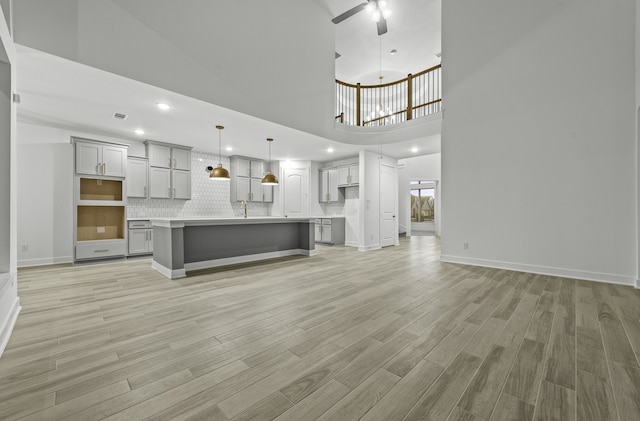 1168 Beals Creek St, Conroe, TX 77304 - unfurnished living room with light wood-style floors, ceiling fan, a high ceiling, and recessed lighting