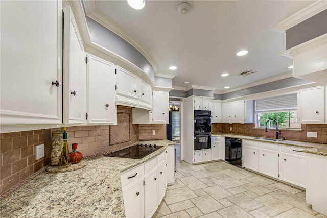 5307 Boyce Springs Dr, Houston, TX 77066 - kitchen featuring black appliances, backsplash, ornamental molding, white cabinetry, and light stone counters