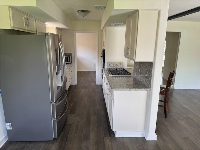 8446 Cabot St, Houston, TX 77078 - kitchen featuring appliances with stainless steel finishes, dark wood-type flooring, and light stone counters
