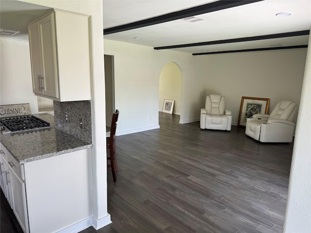 8446 Cabot St, Houston, TX 77078 - kitchen featuring arched walkways, open floor plan, dark wood finished floors, beam ceiling, and decorative backsplash