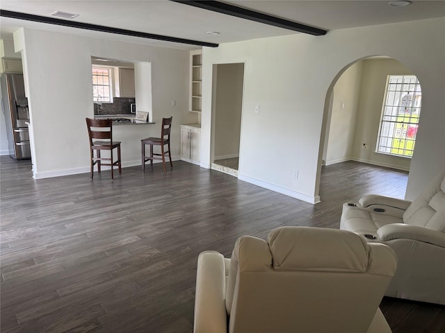 8446 Cabot St, Houston, TX 77078 - living area with arched walkways, plenty of natural light, beamed ceiling, and dark wood finished floors