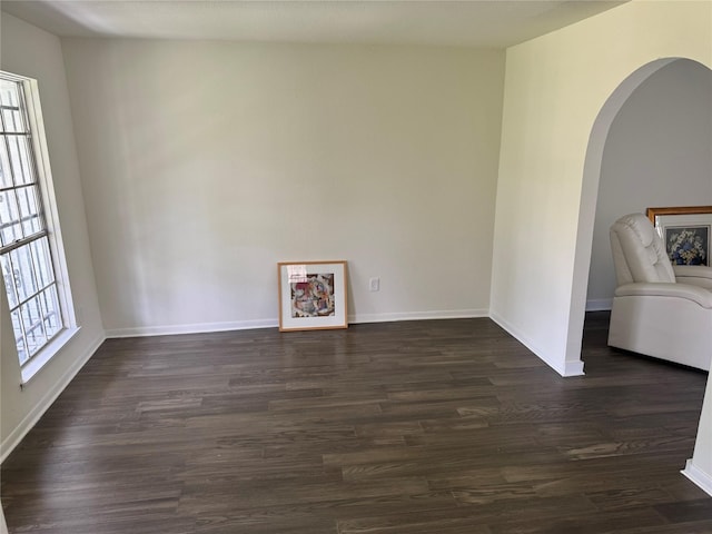 8446 Cabot St, Houston, TX 77078 - spare room featuring arched walkways and dark wood-type flooring