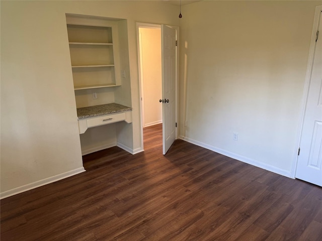 8446 Cabot St, Houston, TX 77078 - unfurnished bedroom with built in desk and dark wood-style flooring
