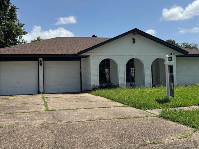 8446 Cabot St, Houston, TX 77078 - view of front of house with brick siding, a shingled roof, driveway, and a garage