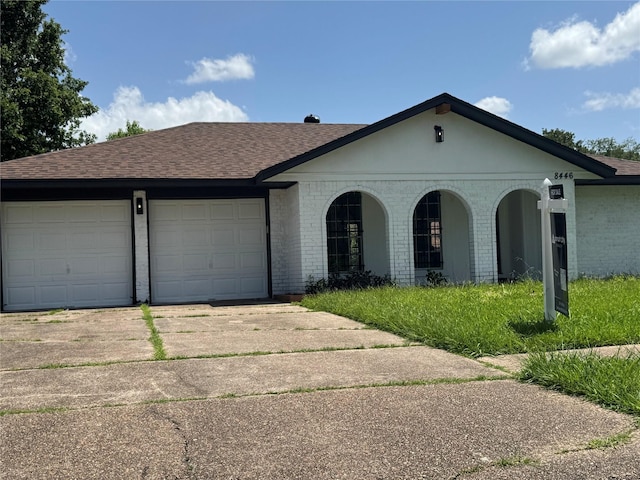 8446 Cabot St, Houston, TX 77078 - view of front of house with brick siding, concrete driveway, a shingled roof, and an attached garage