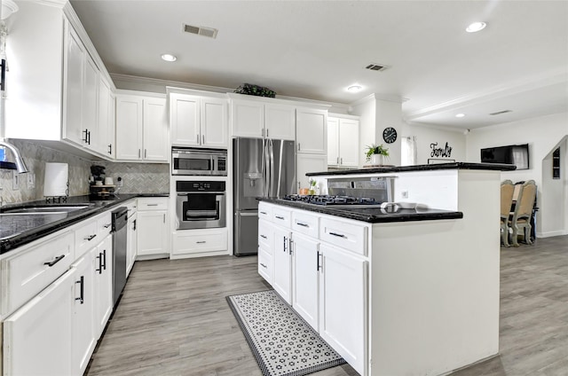 1802 Kowis St, Houston, TX 77093 - kitchen featuring stainless steel appliances, light wood finished floors, a center island, white cabinets, and recessed lighting