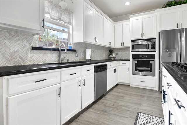 1802 Kowis St, Houston, TX 77093 - kitchen featuring stainless steel appliances, dark countertops, white cabinetry, tasteful backsplash, and recessed lighting