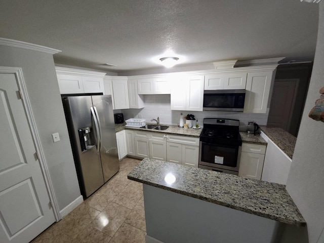 6227 Cavalier St Unit 770, Houston, TX 77087 - kitchen with stainless steel appliances, white cabinetry, light stone countertops, a peninsula, and decorative backsplash