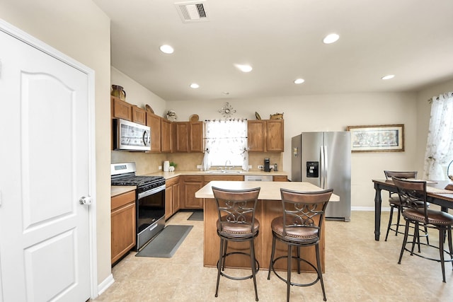3811 Rosalind Ln, Houston, TX 77053 - kitchen with appliances with stainless steel finishes, light countertops, a kitchen bar, a center island, and recessed lighting