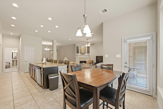 166 Hearthshire Cir, Magnolia, TX 77354 - dining area with a chandelier, light tile patterned floors, a fireplace, recessed lighting, and ceiling fan