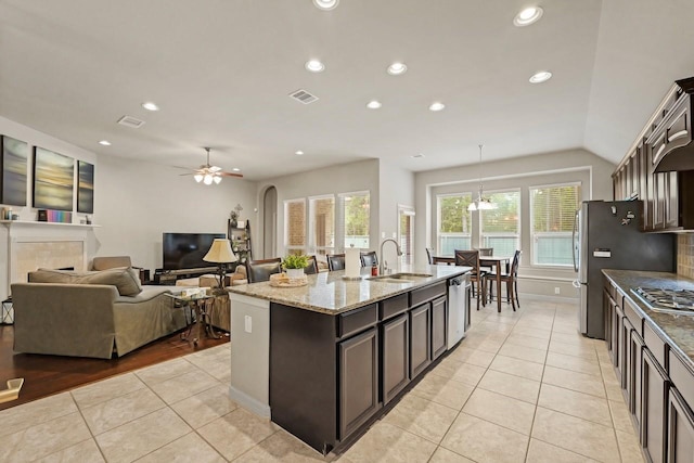 166 Hearthshire Cir, Magnolia, TX 77354 - kitchen featuring appliances with stainless steel finishes, light tile patterned flooring, light stone counters, an island with sink, and recessed lighting