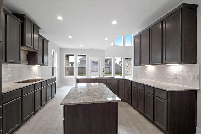 3040 Mesquite Pod Trl, Conroe, TX 77301 - kitchen with light stone countertops, light wood finished floors, recessed lighting, black electric stovetop, and a peninsula