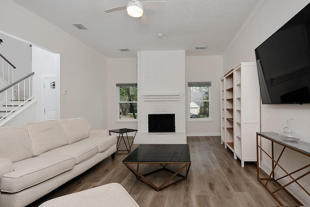 3 Meadow Beauty, The Woodlands, TX 77381 - living area featuring wood finished floors, stairway, ceiling fan, crown molding, and a textured ceiling