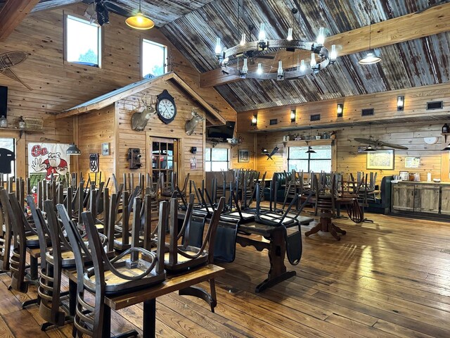 203 W Elder St, Colmesneil, TX 75938 - exercise room featuring wooden walls, plenty of natural light, high vaulted ceiling, and hardwood / wood-style flooring