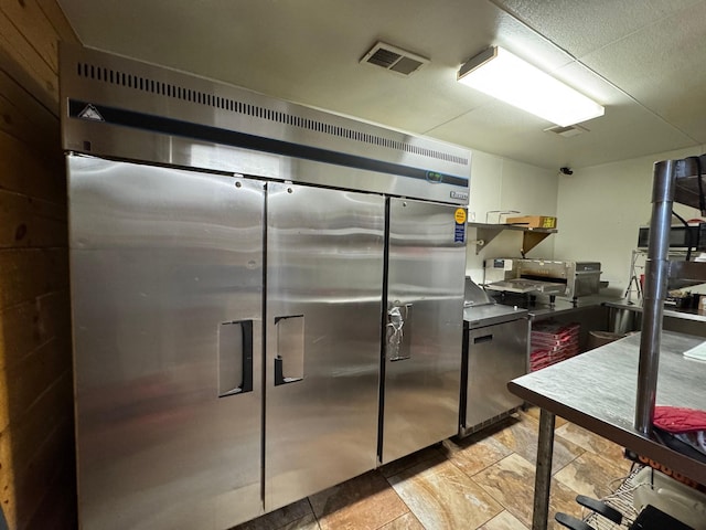 203 W Elder St, Colmesneil, TX 75938 - kitchen featuring white cabinetry, stone finish floors, and fridge