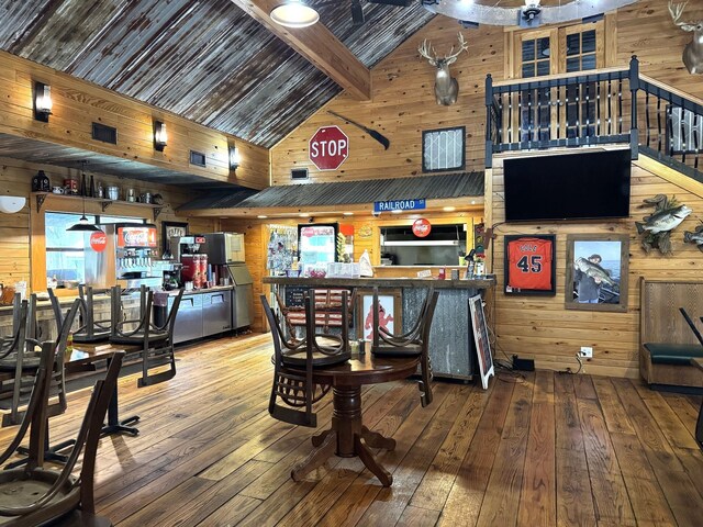 203 W Elder St, Colmesneil, TX 75938 - dining room with wooden walls, wood-type flooring, and high vaulted ceiling