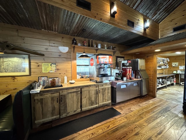 203 W Elder St, Colmesneil, TX 75938 - kitchen featuring wooden walls, wood-type flooring, and freestanding refrigerator