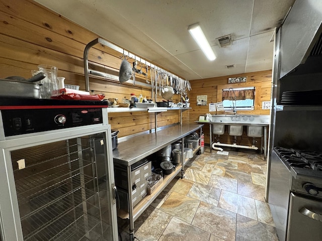 203 W Elder St, Colmesneil, TX 75938 - kitchen featuring wood walls, stone finish floors, and beverage cooler