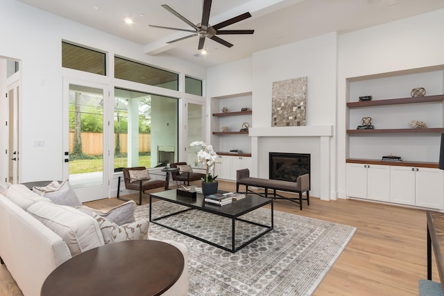 512 W Alkire Lake Dr, Sugar Land, TX 77478 - living room featuring a glass covered fireplace, built in shelves, light wood-style floors, ceiling fan, and recessed lighting