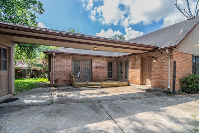 5606 Water Leaf Ln, Houston, TX 77088 - doorway to property with french doors, brick siding, a patio, and roof with shingles