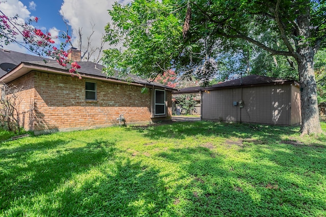 5606 Water Leaf Ln, Houston, TX 77088 - back of house featuring brick siding, a yard, a chimney, and an outdoor structure