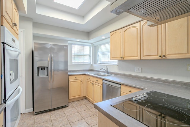 5606 Water Leaf Ln, Houston, TX 77088 - kitchen with appliances with stainless steel finishes, light brown cabinets, exhaust hood, light tile patterned floors, and a tray ceiling