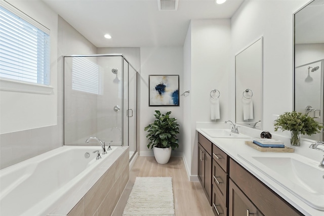 1013 Erin St Unit W, Houston, TX 77009 - bathroom with a garden tub, a shower stall, double vanity, recessed lighting, and wood finished floors