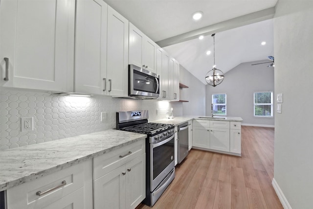 411 E 37th St, Houston, TX 77018 - kitchen featuring stainless steel appliances, a peninsula, light wood-style flooring, white cabinetry, and lofted ceiling