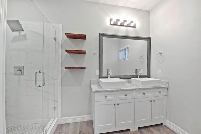 411 E 37th St, Houston, TX 77018 - bathroom featuring a marble finish shower, wood finished floors, and double vanity