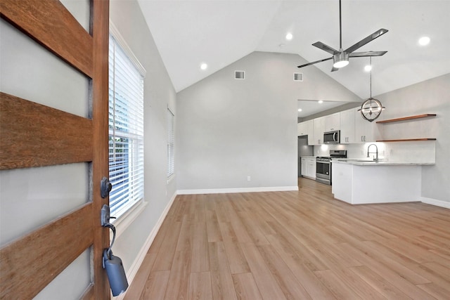 411 E 37th St, Houston, TX 77018 - unfurnished living room featuring a ceiling fan, light wood-style flooring, a chandelier, high vaulted ceiling, and recessed lighting