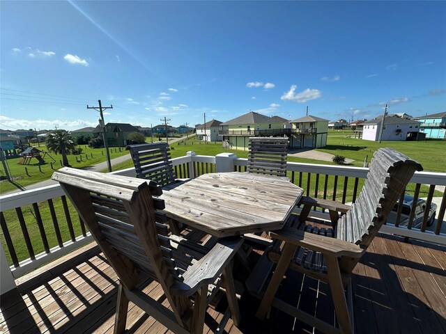 2429 Sand Bar Ln, Crystal Beach, TX 77650 - wooden terrace featuring a residential view, a lawn, and outdoor dining space