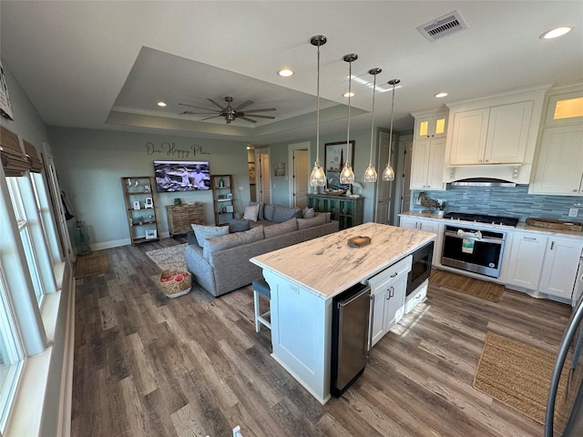 2429 Sand Bar Ln, Crystal Beach, TX 77650 - kitchen with oven, built in microwave, light countertops, dark wood finished floors, and white cabinetry