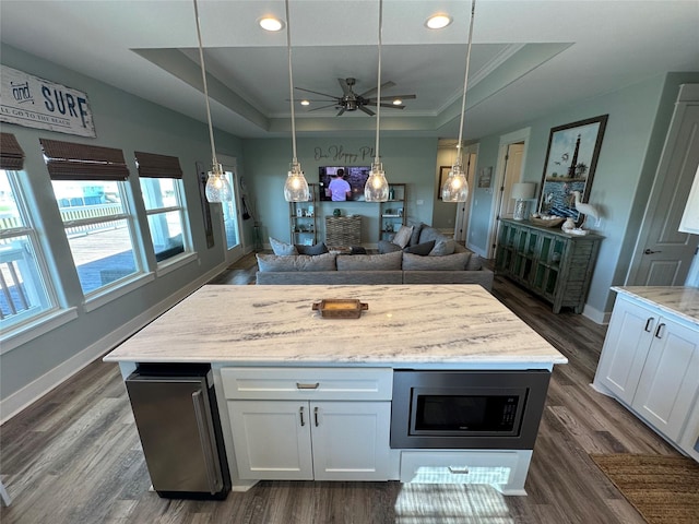 2429 Sand Bar Ln, Crystal Beach, TX 77650 - kitchen with stainless steel microwave, a tray ceiling, white cabinetry, recessed lighting, and open floor plan